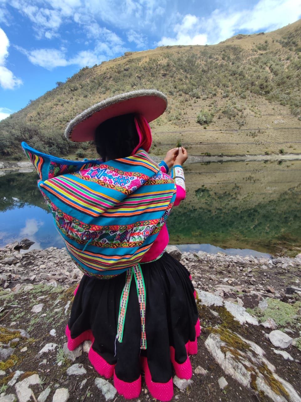 Young andean lady making an offering to the Apus