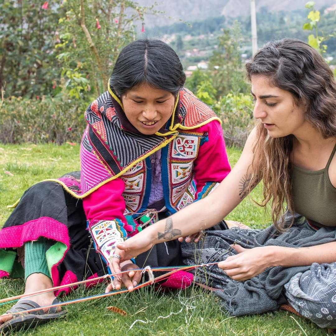 Young andean lady teaching a foraigner about her culture and traditions
